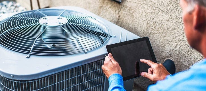 Kevin Robinson's Heating & Cooling | Lancaster, Kershaw, Lugoff, Camden, Indian Land, Heath Springs, SC | Maintenance engineer using digital tablet to inspect air conditioning unit
