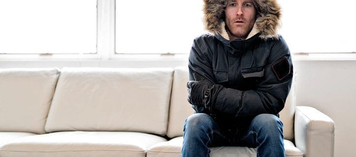 Kevin Robinson's Heating & Cooling | Lancaster, Kershaw, Lugoff, Camden, Indian Land, Heath Springs, SC | Man With Warm Clothing Feeling The Cold Inside House on the sofa